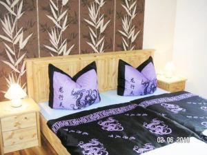 a bedroom with a bed with purple and white pillows at FH Charlottchen_WEIG in Ostseebad Karlshagen
