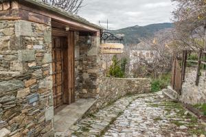 un viejo edificio de piedra con un cartel. en Iliopetra Suites en Agios Lavredios