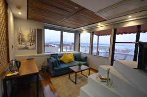 イスタンブールにあるÜnver Galata Apartのリビングルーム(ソファ付)が備わります。一部の窓があります。