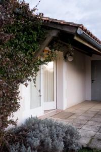 a white house with a door on the side of it at La Bribaudonnière in Saint-Palais-de-Phiolin