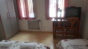 a room with a bed and a table and windows at Guest House - Batak in Batak