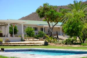 a house with a swimming pool in front of it at Koedoeskop Private Mountain Reserve in Hoekskraal