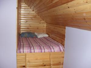 a bedroom with a bed in a wooden cabin at Pohulanka - Białowieża in Kolonia Pohulanka