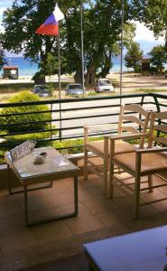 un patio con 2 sillas, una mesa y una sombrilla en Stefanidis Platani Beach, en Stavros