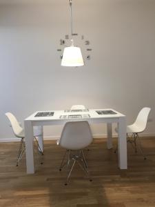 a white table with four chairs and a light fixture at Bartolo Suite Centro Storico Perugia in Perugia