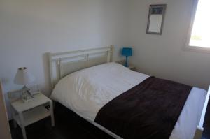 a bedroom with a bed and a table with a lamp at Port Mezua in Mèze