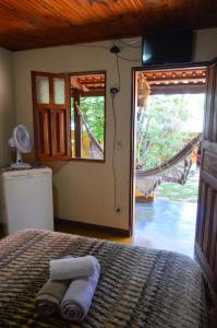 a bedroom with a bed and a large window at Pousada Beija-Flor in Alto Paraíso de Goiás