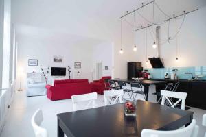 a living room with a red couch and white chairs at Splendid Trees Apartment in Budapest