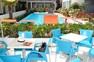 a group of tables and chairs next to a swimming pool at Hotel International in Senigallia