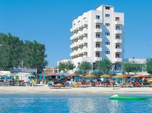 a beach with umbrellas and a large building at Hotel International in Senigallia