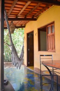 um pátio com uma mesa e uma rede de descanso fora de uma casa em Pousada Beija-Flor em Alto Paraíso de Goiás