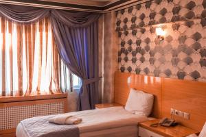 a small bedroom with a bed and a window at Peracity Hotel in Ankara