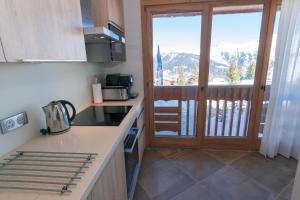 a kitchen with a balcony with a view of a mountain at Chalet A03 in Courchevel