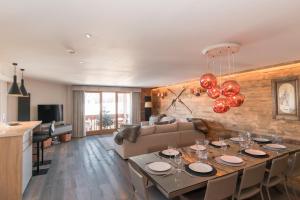 a dining room and living room with a dining table at Chalet A03 in Courchevel