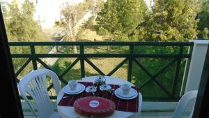 a table with a tea set on a balcony at Apartamento Urb. Vila Nova, Lote 5 in Armação de Pêra