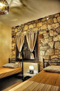 プサコウディアにあるSunstone Villasの石壁のドミトリールーム ベッド2台