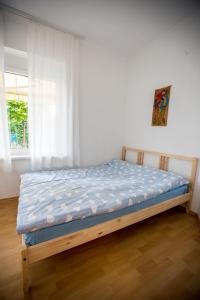 - un lit dans une chambre avec fenêtre dans l'établissement Schieszl Apartments Zamárdi 2, à Zamárdi
