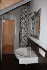 ein Badezimmer mit einem weißen Waschbecken und einem Spiegel in der Unterkunft Ferienwohnung in Marburg/Wehrda in Marburg an der Lahn