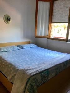 una cama en un dormitorio con ventana en Toscana Mare Suite-Ronchi - Riviera Apuana, en Massa