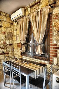 eine Küche mit einem Tisch mit Stühlen und einem Fenster in der Unterkunft Villa Eleana in Psakoudia