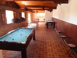 a pool table in a room with two tables and chairs at Pousada Chalés da Felicidade in Itu