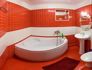ヘルソンにあるJohn Howard Pub Central Apartment 2 roomの赤いタイル張りのバスルーム(バスタブ、シンク付)