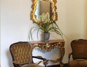 a table with a mirror and a vase of flowers at Casablanca Koeler in Petrópolis