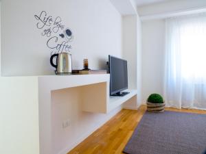 a living room with a tv on a white wall at Bartolo Suite Centro Storico Perugia in Perugia +20 photos