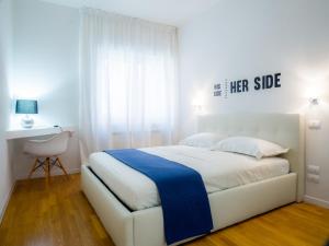 sypialnia z białym łóżkiem i niebieskim kocem w obiekcie Bartolo Suite Centro Storico Perugia w mieście Perugia