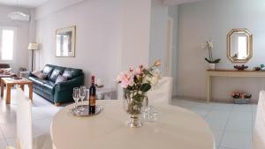 un soggiorno con un vaso di fiori su un tavolo di Heraklion Old Port Apartments a Heraklion