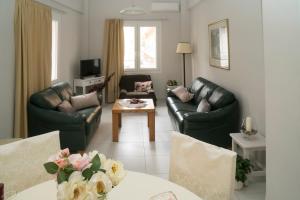 salon z 2 skórzanymi kanapami i stołem w obiekcie Heraklion Old Port Apartments w Heraklionie