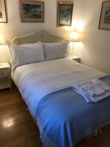 a bedroom with a large white bed with blue sheets at Fulham B&B in London