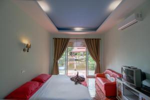 a bedroom with a bed and a tv and a couch at Best House Resort in Ban Pak Ba Ra