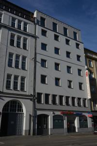 a tall gray building with windows on a street at Arthotel Munich in Munich