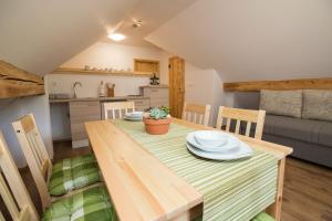 a dining room with a table and chairs and a kitchen at TriSa apartments Bohinj in Bohinj
