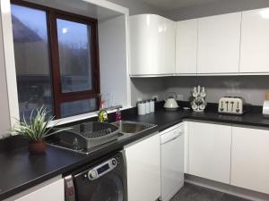 a kitchen with white cabinets and a sink at Number 13 in Lerwick