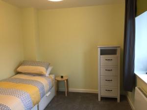 a bedroom with two twin beds and a dresser at Number 13 in Lerwick