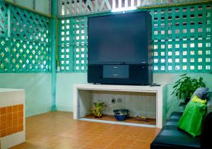 a living room with a large screen tv on a table at Cozycomo Chanthaburi in Chanthaburi