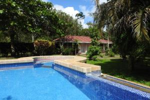 a swimming pool in front of a house at Hotel de Campo Caño Negro in Caño Negro