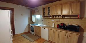 a kitchen with wooden cabinets and a stove top oven at Apartments in Villa Barbara in Świeradów-Zdrój