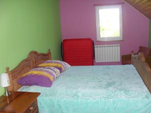 a bedroom with a bed and a red chair at Pohulanka - Białowieża in Kolonia Pohulanka