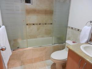 y baño con aseo, ducha y lavamanos. en Torres Bosmediano, en Quito