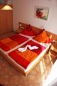 a bedroom with a large bed with red and orange blankets at Case Bellissime in Tronzano Lago Maggiore