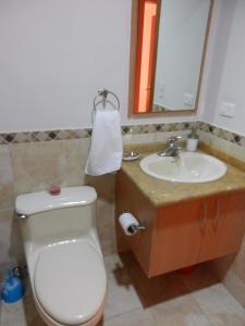 y baño con aseo, lavabo y espejo. en Torres Bosmediano, en Quito