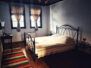 a bedroom with a bed and two windows at Khan Staria Dobrich Family Hotel in Dobrich