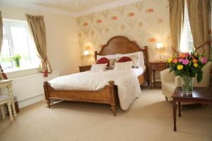 - une chambre avec un lit et un vase de fleurs dans l'établissement The Pytchley Inn, à West Haddon