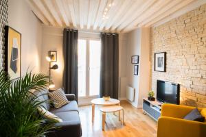 a living room with a couch and a tv at Le Sathonay - Loft Terrasse - Lyon Centre - Majord'Home in Lyon