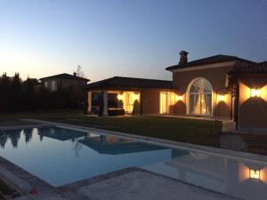 a house with a swimming pool at night at Front Row Golf Villa Bogogno in Bogogno