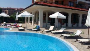 una piscina con tumbonas y sombrillas en Coastal Dreams complex en Sveti Vlas