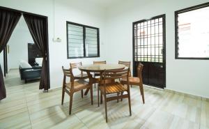 una sala da pranzo con tavolo e sedie di SingVillage Holiday House a Mersing